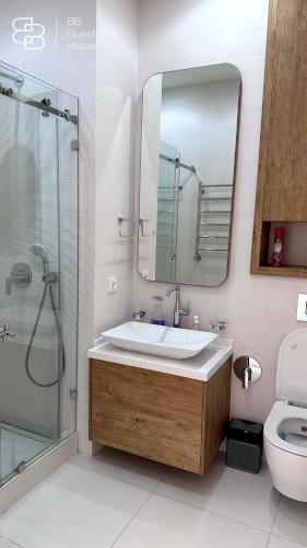 a bathroom with a sink and a mirror and a toilet at Boulevard 46 in Tashkent