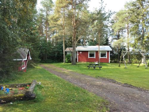 a red cabin with a picnic table and a playground at Punainen tupa in Kalajoki