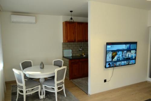 a dining room with a table and a tv on a wall at Spacious and Modern Apartment in Town Center in Konjic