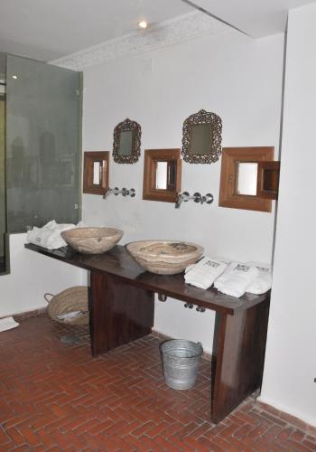 a bathroom with two sinks and two mirrors at Hotel Blanco Riad in Tetouan