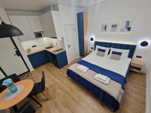 ein Schlafzimmer mit einem Bett und einem Tisch sowie eine Küche in der Unterkunft DeMar Apart STAR in Lwiw