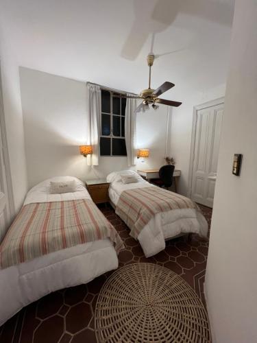 a bedroom with two beds and a ceiling fan at Refugio Francés en Buenos Aires in Buenos Aires