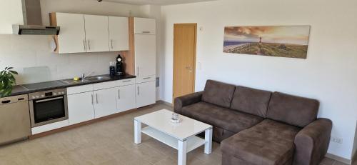 ein Wohnzimmer mit einem Sofa und einem Tisch in der Unterkunft Ferienwohnung Am Philosophenweg in Hachenburg