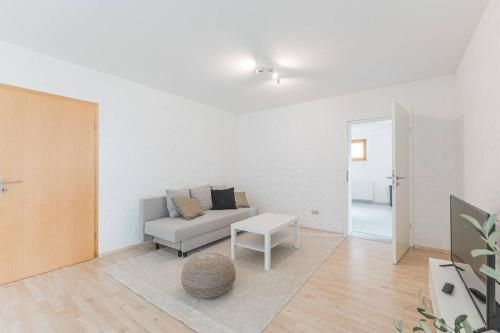 a living room with a couch and a table at G01 schöne Souterrainwohnung - Self Check-In ideal für Teams und Monteure in Gäufelden