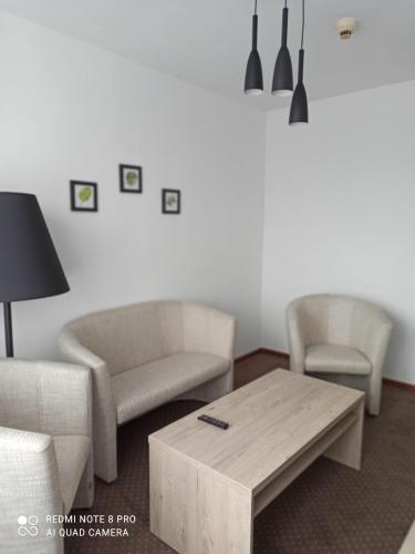 a living room with two chairs and a coffee table at HOTEL ODR in Sulechów