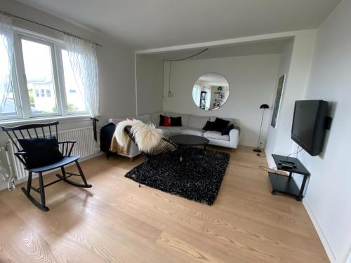 a living room with a couch and a table at 1 Bedroom Home - Private Balcony - Parking On Site in Tórshavn