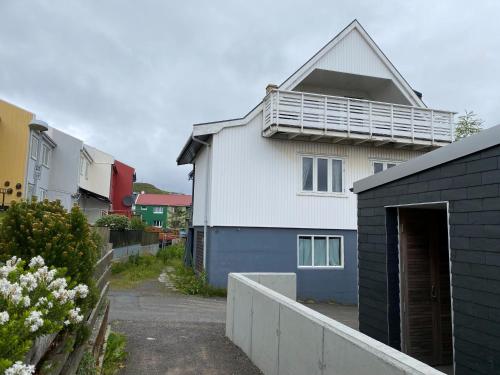 a white house with a balcony on top of it at 1 Bedroom Home - Private Balcony - Parking On Site in Tórshavn