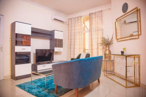 a living room with a blue couch and a television at RIVER APPARTS in Brazzaville