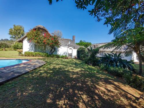 a house with a yard with a swimming pool at Emfuleni Boughton Inn in Pietermaritzburg