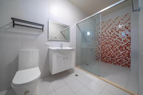 a bathroom with a toilet and a shower and a sink at Happy play villa in Yuanshan