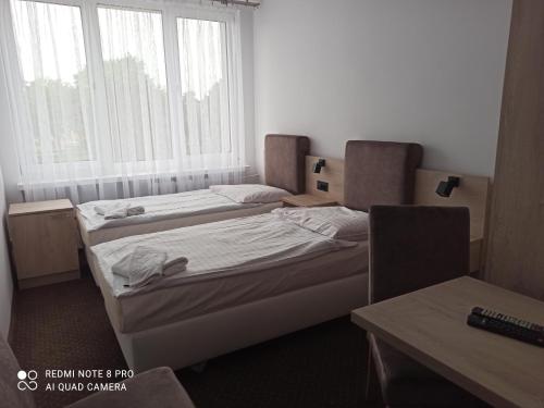 two beds in a small room with a window at HOTEL ODR in Sulechów