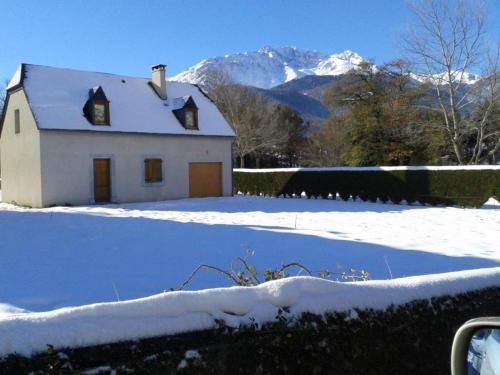 a white house in the snow with mountains in the background at Jolie Maison Vallee D'aure 4étoiles in Pailhac