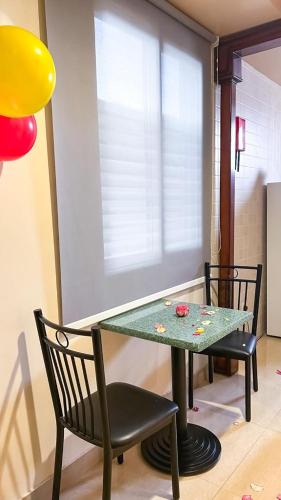 a dining room table with two chairs and a green table at Levant Hotel فندق قصر المشرق in Najran