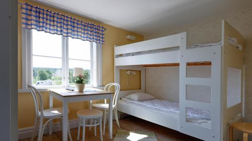 a bedroom with a bunk bed and a table and chairs at Skeppsdockans Vandrarhem in Söderköping