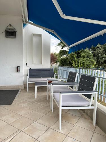 a patio with two benches and a blue umbrella at Hotel Airone in Alberobello