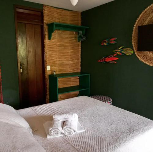 una camera da letto con un letto e un asciugamano sopra di Happy Paradise a Natal