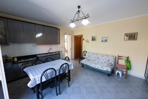 una cocina con mesa y sofá. en Appartanvilla con giardino terrazzo e parcheggio privato, en Mascali