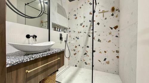 W łazience znajduje się umywalka i prysznic. w obiekcie Luksusowe Apartamenty na Toruńskiej w mieście Kwidzyn