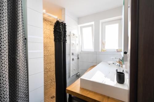 bagno con lavandino bianco e doccia di Appartement des Sorcieres - Witches Apartment a Sélestat