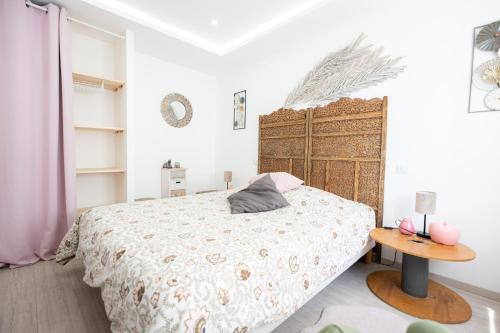 um quarto com uma cama e uma cabeceira em madeira em Appartement des Sorcieres - Witches Apartment em Sélestat