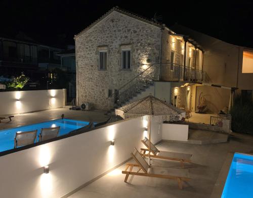 eine Villa mit einem Pool in der Nacht in der Unterkunft Mangata suites homes with private pools in Meganisi