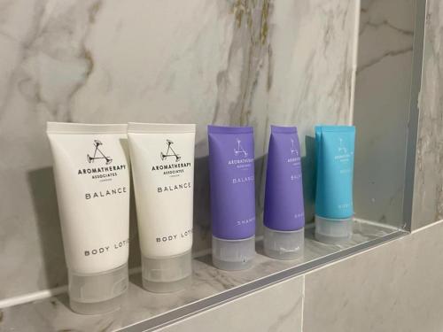 a group of four bottles of shampoo and conditioner on a shelf at Valkla Puhkekeskus - Merevaatega SVIIT in Salmistu