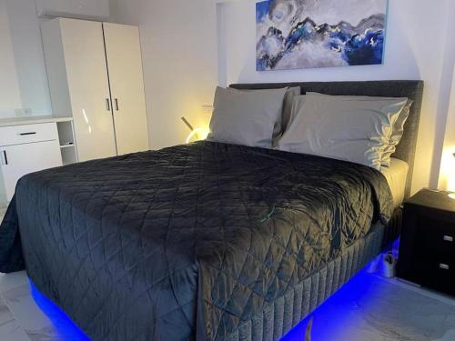 a bed with a black comforter in a bedroom at Valkla Puhkekeskus - Merevaatega SVIIT in Salmistu