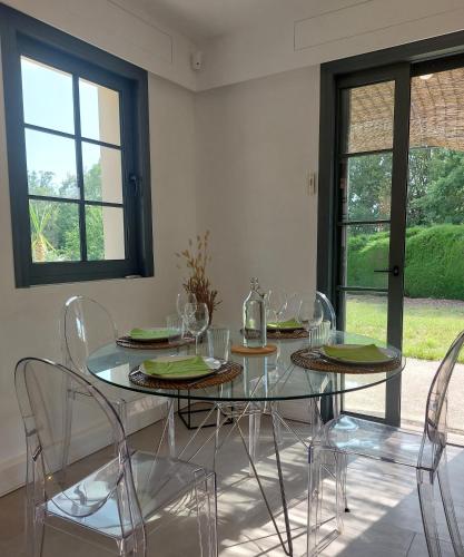 une salle à manger avec une table et des chaises en verre dans l'établissement La petite maison, à Châteauneuf