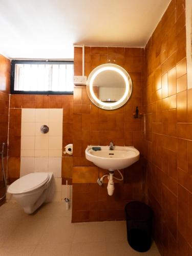 a bathroom with a sink and a toilet and a mirror at Casa Do Leão A 150 year Old Portuguese Home in Nerul
