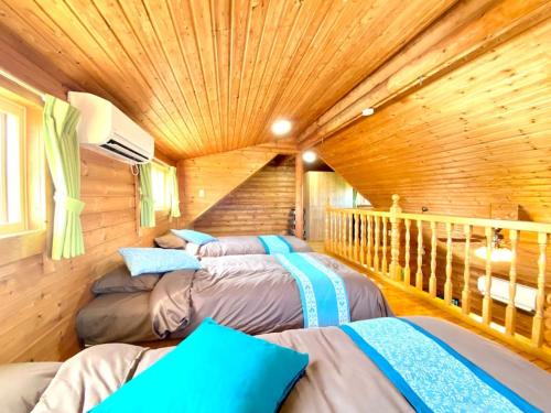 a room with three beds in a log cabin at on a journey 千葉 九十九里 in Kujukuri