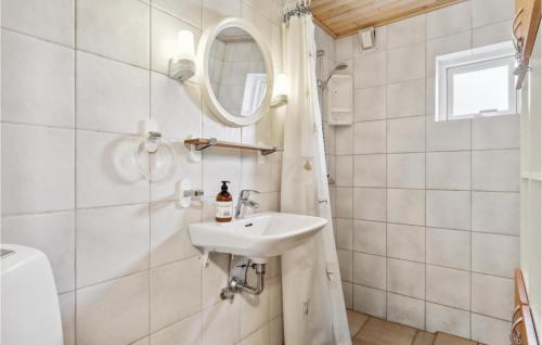 een badkamer met een wastafel en een spiegel bij Beautiful Home In Skagen With Wifi in Skagen