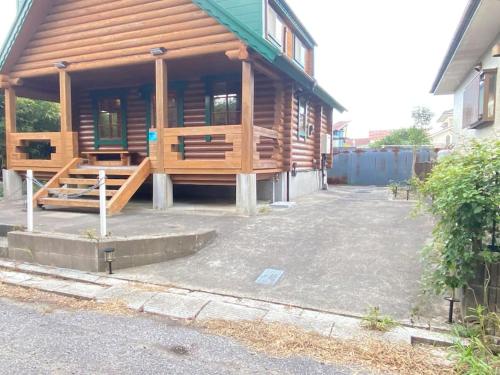 a log cabin with a porch and a building at on a journey 千葉 九十九里 in Kujukuri