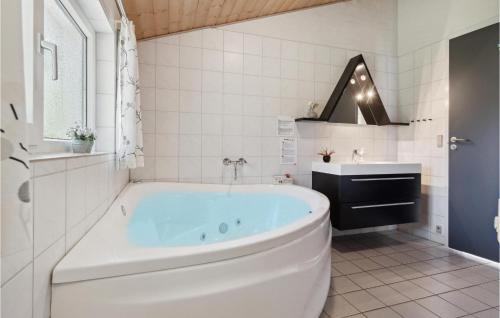 uma casa de banho branca com uma banheira e um lavatório em Nice Home In Blvand With Wifi em Blåvand