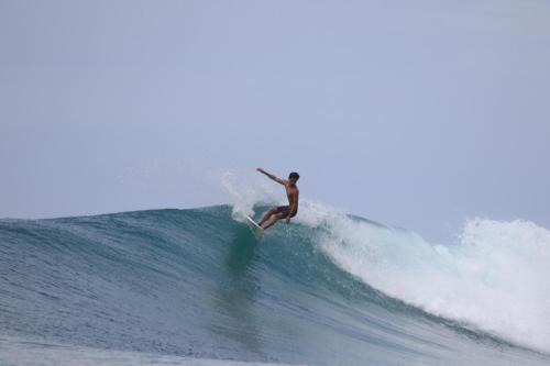 Człowiek na fali na desce surfingowej w oceanie w obiekcie Endi Surf Camp w mieście Lagudri