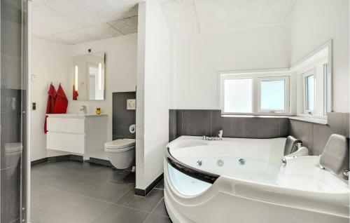 baño blanco con bañera y aseo en Lovely Home In Hjrring With Kitchen, en Vester Vidstrup