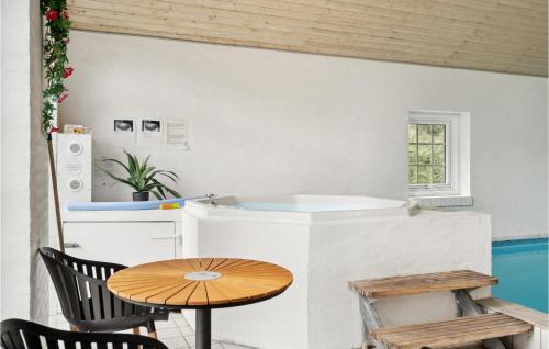 Cozy Home In Rm With Indoor Swimming Pool في رومو كيركيبي: مطبخ صغير مع طاولة وكراسي خشبية