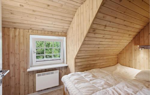 Cozy Home In Rm With Indoor Swimming Pool في رومو كيركيبي: غرفة نوم صغيرة بها سرير ونافذة