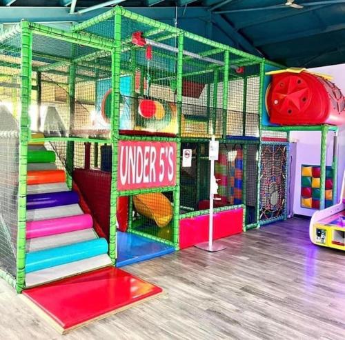 una sala de juegos con coloridos equipos de juego y escaleras en 8 person static caravan en Heysham