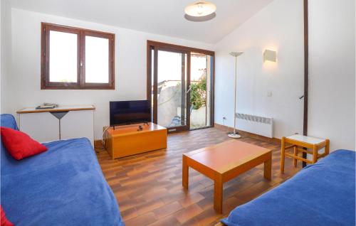 un salon avec un canapé bleu et une table dans l'établissement 2 Bedroom Cozy Home In Porticcio, à Porticcio