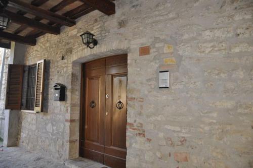 a stone building with a wooden door in front of it at La Casa sull'Archetto in Corciano
