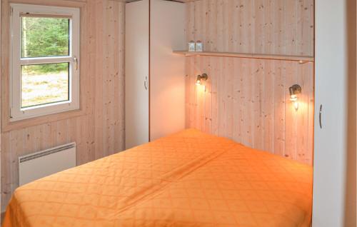 an orange bed in a room with a window at Amazing Home In Lkken With 3 Bedrooms And Sauna in Grønhøj