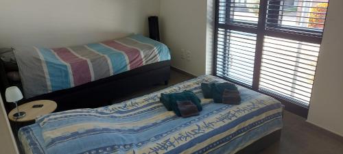 a small bedroom with two beds and a window at Leuk overnachten in hartje Laarne, dicht bij Gent! in Laarne