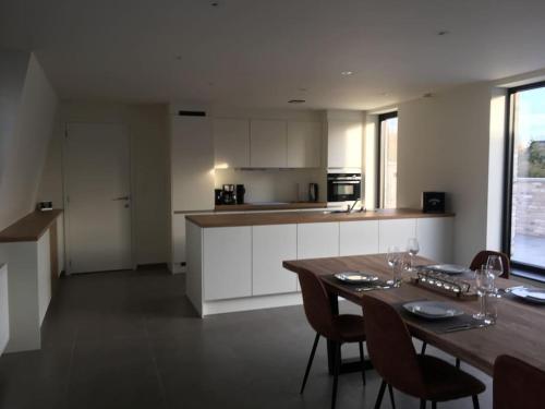 cocina con mesa de madera y sillas en una habitación en Leuk overnachten in hartje Laarne, dicht bij Gent!, en Laarne