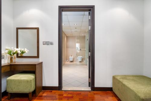 a room with a desk and a mirror and a bathroom at Lux BnB I Palm Jumeirah Resort I Palm Views in Dubai
