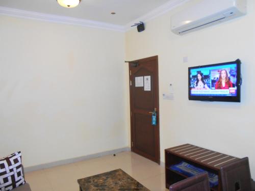 a living room with a tv on a wall at Nizwa Hotel Apartments in Nizwa
