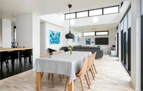 a dining room and living room with a table and chairs at Three-Bedroom Holiday Home In Lokken in Løkken