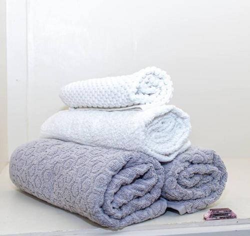 een stapel handdoeken op een plank bij The Homey Haven in Eldoret