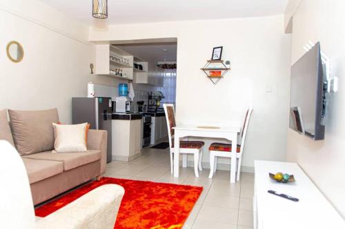 een woonkamer met een bank en een tafel bij The Homey Haven in Eldoret