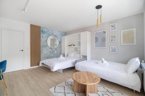 a bedroom with two beds and a coffee table at Blue Morpho Piątkowo Apartment in Poznań