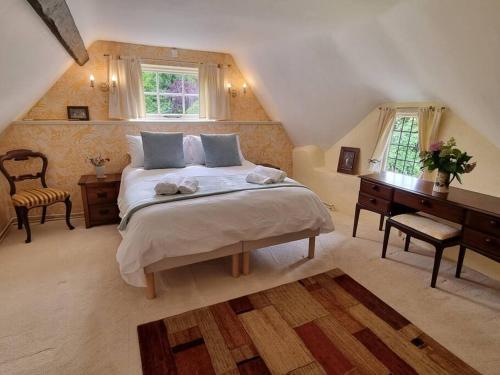 Schlafzimmer mit einem Bett, einem Schreibtisch und einem Fenster in der Unterkunft Smugglers Cottage in Barton on Sea